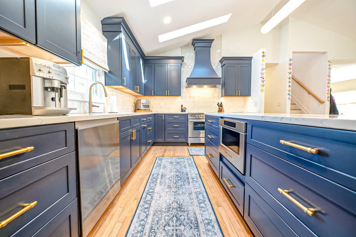 Custom kitchen with navy cabinets and gold hardware in a Long Island Creative Contracting, Inc. home in Miller Place, NY