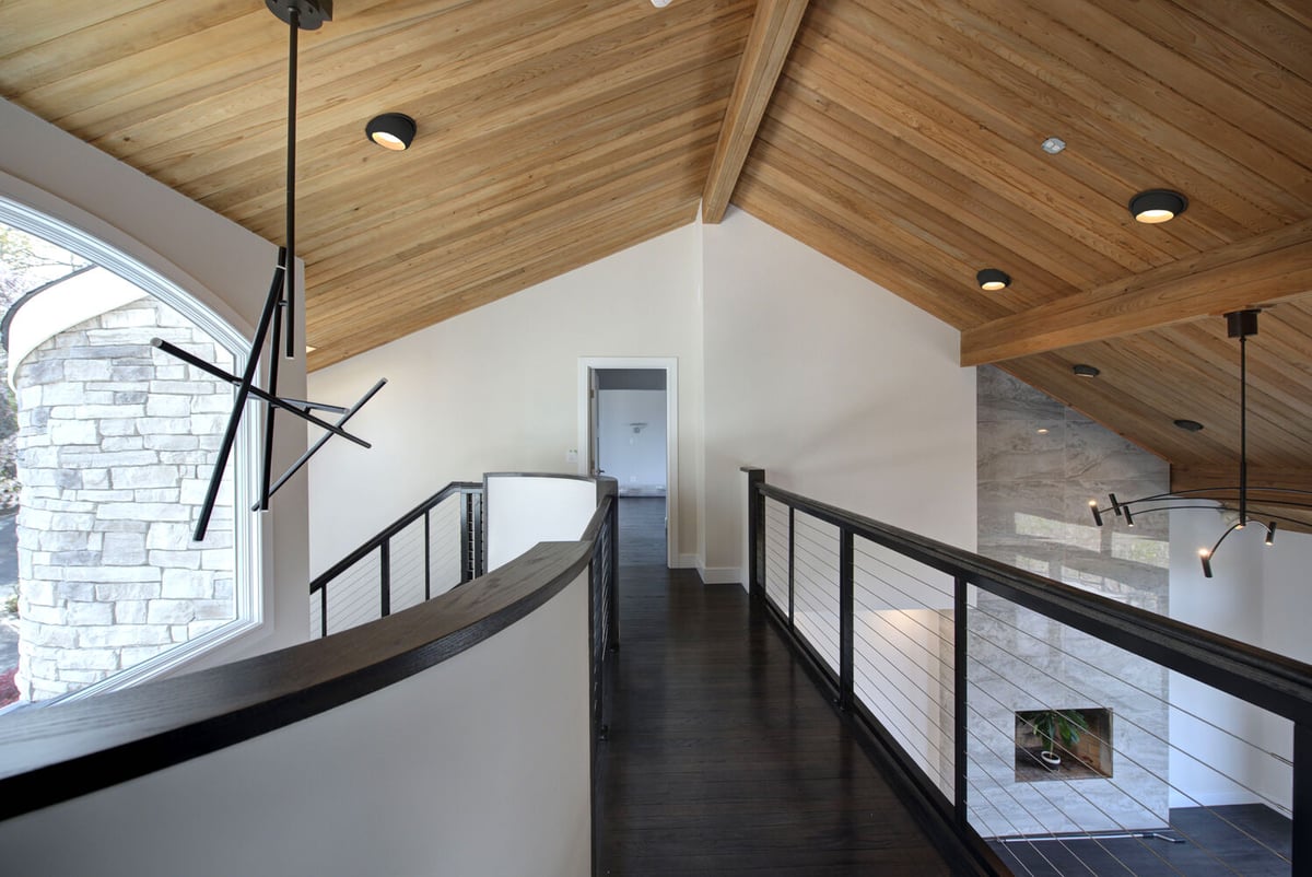 Second-floor walkway with vaulted wood ceiling by Long Island Creative Contracting, Inc. in Setauket, NY